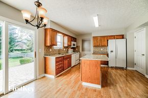 Hilliard house for rent - a kitchen with wooden cabinets and a white refrigerator