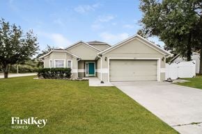 Deltona house for rent - a white house with a driveway and a garage door