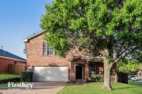 Dallas house for rent - A brick house with a tree in front of it.