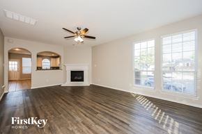 Dallas house for rent - A spacious living room with a fireplace and a ceiling fan.