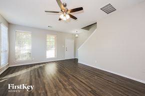 Dallas house for rent - A spacious room with a ceiling fan and wooden flooring.