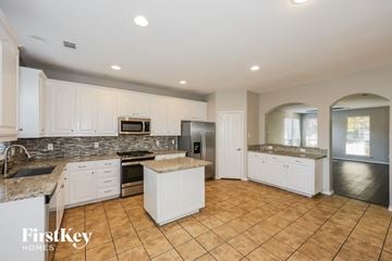 Dallas house for rent - A kitchen with white cabinets and a stone backsplash.