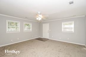 Powder Springs house for rent - a bedroom with white carpet and a ceiling fan