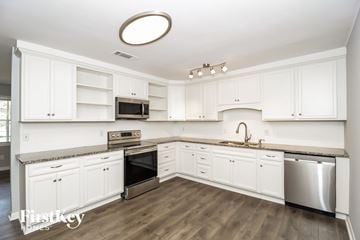 Powder Springs house for rent - a white kitchen with stainless steel appliances and white cabinets