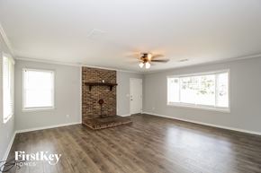 Powder Springs house for rent - a living room with a brick fireplace and a ceiling fan