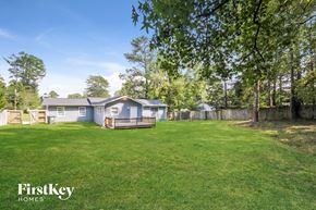 Powder Springs house for rent - a backyard with a house and a yard with grass and trees