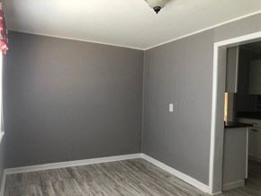 Snyder house for rent - an empty living room with gray walls and a door way