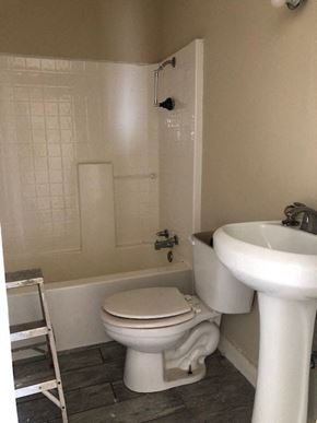 Snyder house for rent - A white toilet sits next to a white sink in a bathroom.