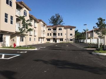 Hialeah apartment for rent - an empty parking lot in front of some buildings