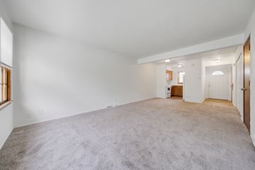 Bloomington apartment for rent - a living room with carpet and a door to a kitchen