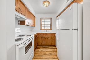 Bloomington apartment for rent - a kitchen with white appliances and wooden cabinets