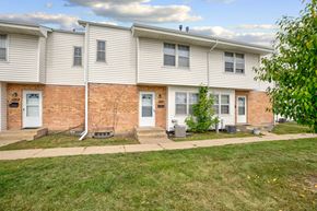 Bloomington apartment for rent - a white house with a brick wall and a sidewalk