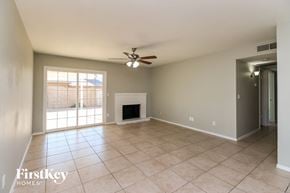 Mesa house for rent - an empty living room with a fireplace and a ceiling fan