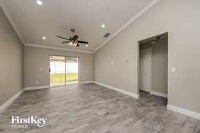 Kissimmee house for rent - the spacious living room with a ceiling fan and a door to the patio