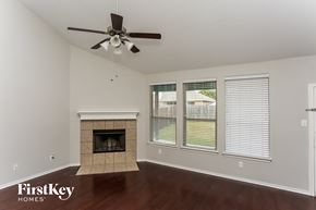 Fort Worth house for rent - a living room with a fireplace and a ceiling fan