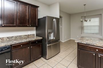 Fort Worth house for rent - a kitchen with wooden cabinets and a stainless steel refrigerator