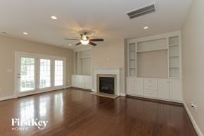 Charlotte house for rent - an empty living room with a ceiling fan and a fireplace