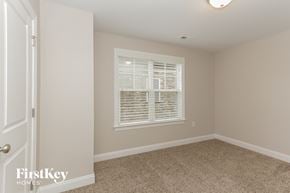 Charlotte house for rent - a bedroom with a large window and a carpeted floor