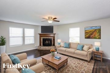 Pendleton house for rent - A living room with a beige couch, a fireplace, and a painting on the wall.