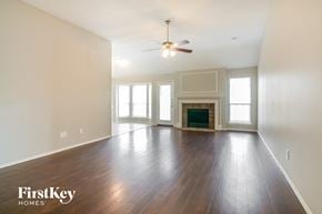 Arlington house for rent - an empty living room with a ceiling fan and a fireplace