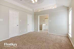 Arlington house for rent - a master bedroom with a carpeted floor and a door to a bathroom