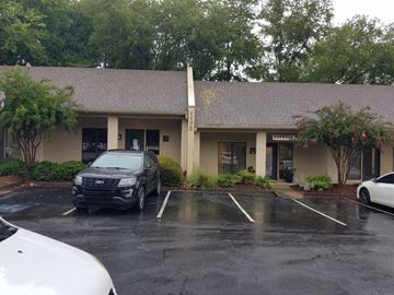 Atlanta apartment for rent - A white car is parked in a parking lot in front of a building.