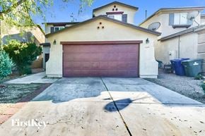 Tucson house for rent - a garage with a brown garage door in front of a house