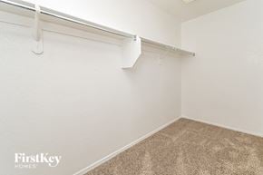 Tucson house for rent - the spacious closet in the master bedroom of a manufactured home with white walls and carpet