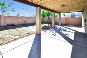 Tucson house for rent - a patio with a wall and trees in the background