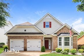 Hiram house for rent - a brick house with white garage doors and a flag on the side