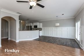 Lawrenceville house for rent - an empty living room and kitchen with a ceiling fan