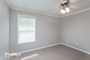 Lawrenceville house for rent - a bedroom with a ceiling fan and a window