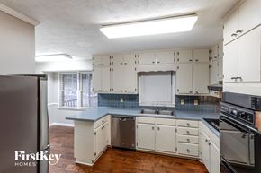 Snellville house for rent - a kitchen with white cabinets and stainless steel appliances