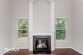 High Pt house for rent - a fireplace in a living room with white pillars and windows