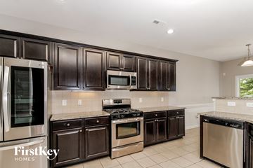 High Pt house for rent - A kitchen with dark brown cabinets and stainless steel appliances.