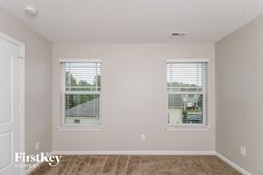 High Pt house for rent - a bedroom with two windows and a carpeted floor