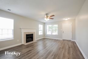 Monroe house for rent - a living room with a fireplace and a ceiling fan