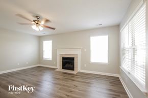 Monroe house for rent - a living room with a fireplace and a ceiling fan