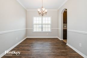 Royse City house for rent - A room with wooden floors and a chandelier hanging from the ceiling.