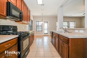 Royse City house for rent - A kitchen with wooden cabinets and a black microwave.
