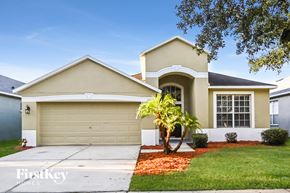 Riverview house for rent - a beige house with a palm tree in front of it