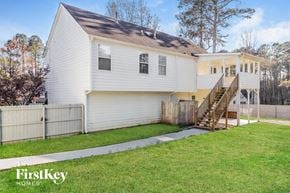Dallas house for rent - a white house with a yard and a wooden fence