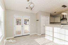 Dallas house for rent - a kitchen and living room with white blinds on the doors and a white counter