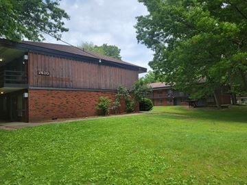 Akron apartment for rent - a view of the front of a building with a lawn and trees