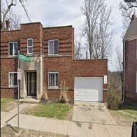 Cincinnati apartment for rent - A brick building with a white garage door in front.