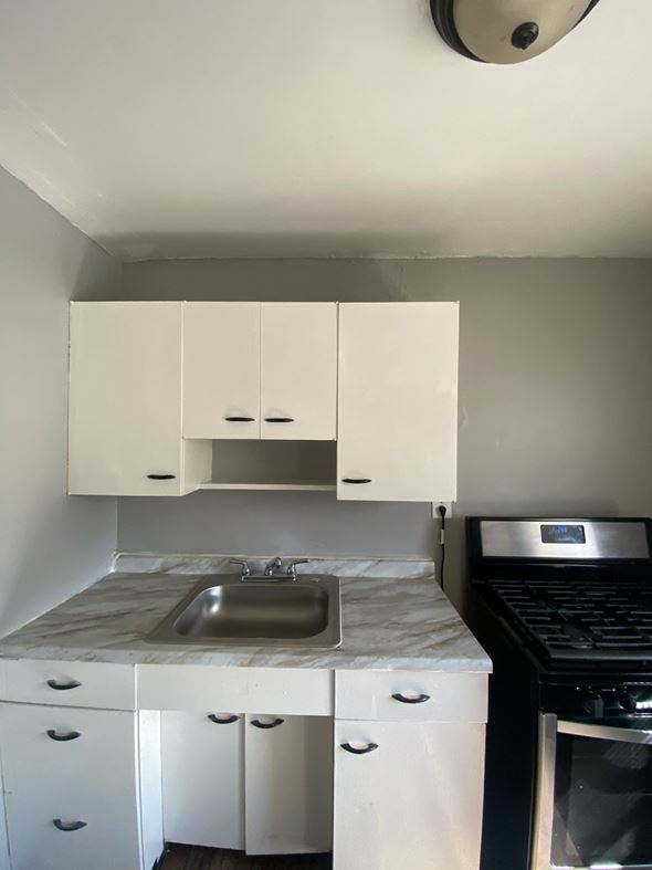 Cincinnati apartment for rent - A kitchen with white cabinets and a marble countertop.