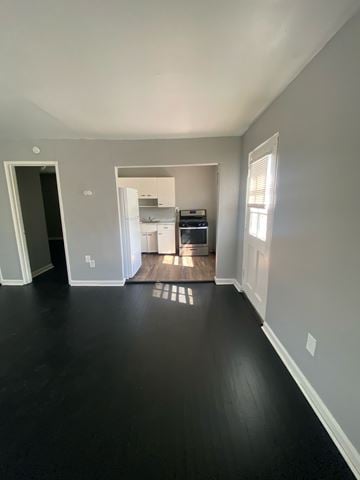 Cincinnati apartment for rent - A kitchen with white cabinets and appliances is visible through an open doorway.