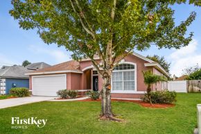 Jacksonville house for rent - A tree stands in front of a house with a sign that says "FirstKey Homes".