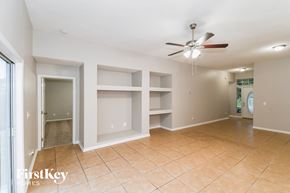 Jacksonville house for rent - A spacious room with a ceiling fan and empty shelves.