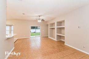 Jacksonville house for rent - A spacious room with a tiled floor and a ceiling fan.